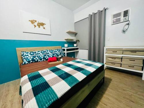 马尼拉Cozy Place Anuva Residences的一间卧室配有一张带蓝白色毯子的床