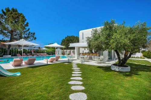 弗尔卡Cocoοns Luxury Suites & Villas的一个带树和椅子的游泳池的庭院