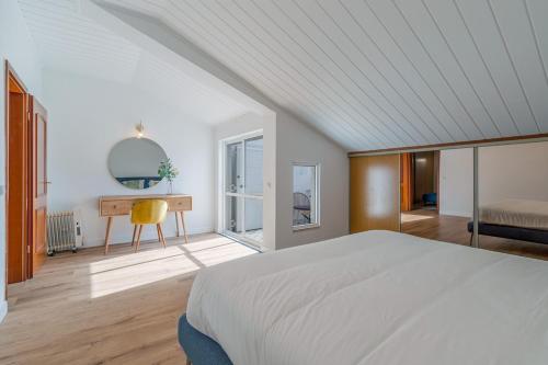 塞图巴尔Setúbal Oasis House的一间卧室配有一张床、一张书桌和一个窗户。