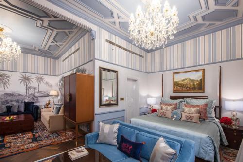 新德里克拉瑞芝新德里酒店的一间卧室配有蓝色的床和吊灯。