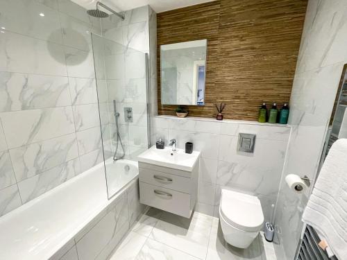 切姆Super Cosy Apartment in The Heart Of Chelmsford的白色的浴室设有浴缸、卫生间和水槽。