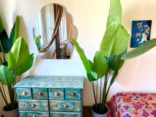 布达佩斯Lovely cosy art flat的一间种植了植物的房间,一个蓝色梳妆台和镜子