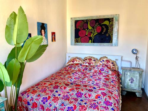 布达佩斯Lovely cosy art flat的卧室配有一张床,墙上挂有绘画作品