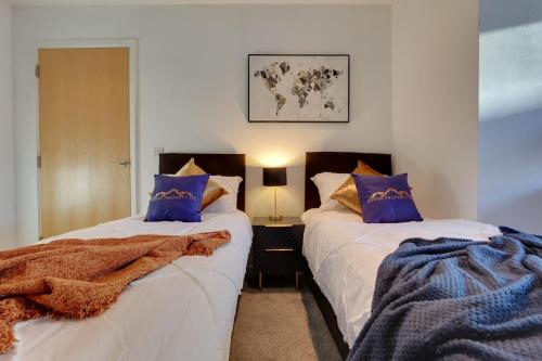 谢菲尔德Home Away From Home - Contractors & Leisure的一间卧室配有两张带蓝色枕头的床