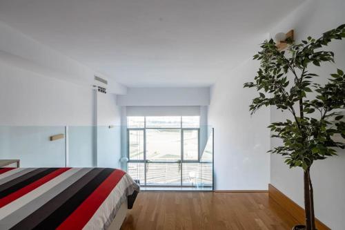 瓦伦西亚Duplex LOFT Apartamento con Parking GRATIS的一间卧室配有一张床和盆栽植物