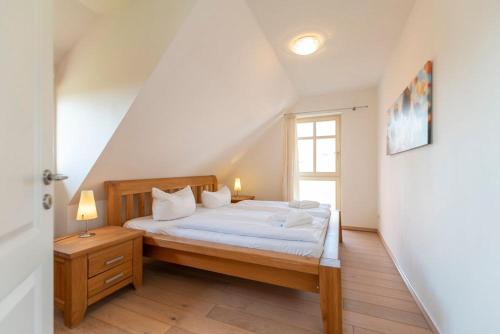 KarninFerienhaus Karnin A的一间卧室配有一张带白色床单的床和一扇窗户。