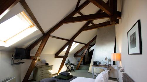 鹿特丹品克弗套房酒店的一间卧室设有木梁、一张床和一张书桌。