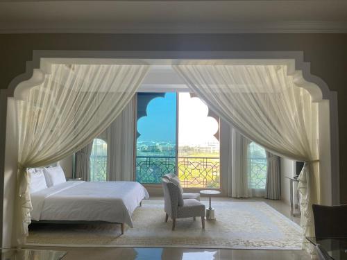 拉斯阿尔卡麦Private Suites Al Hamra Palace at golf & sea resort的一间卧室设有一张床和一个大窗户
