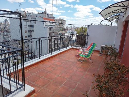 布宜诺斯艾利斯Hermoso Departamento en Recoleta muy luminoso的大楼顶部带绿椅的阳台