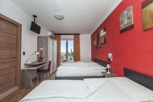 马尔切西内加尼伊斯基亚酒店的酒店客房设有两张床和红色的墙壁。