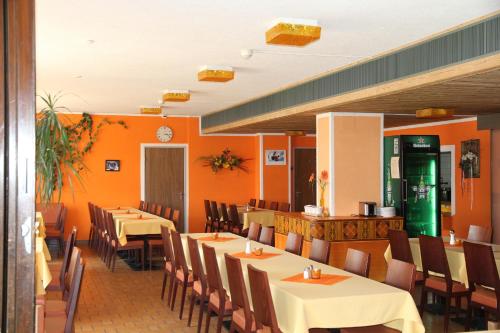 圣莫里茨斯提勒酒店的一间带桌椅和橙色墙壁的餐厅