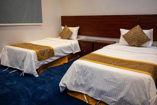 利雅德Ahlin Suites 5的一间酒店客房,房间内设有两张床