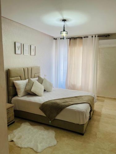 卡萨布兰卡Superbe Appartement au coeur de Casablanca的卧室配有一张带白色窗帘的大床