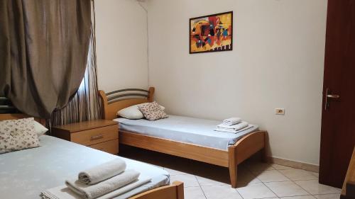 萨兰达Guesthouse Villa Joanna&Mattheo的小房间设有两张床,墙上挂着一张照片