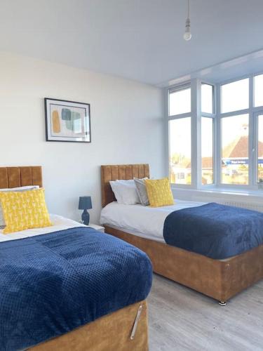 弗特威克Flitwick Luxury Apartment的一间卧室设有两张床和窗户。