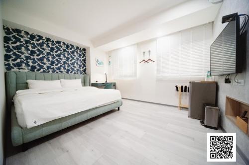 虎尾镇虎尾小9窩的卧室配有白色的床和蓝色图案的墙壁