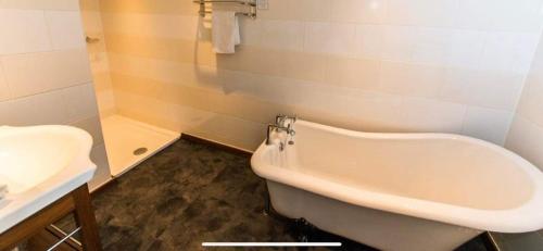 德比The Bubble Inn Hotel的浴室配有白色浴缸和水槽