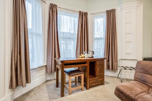 贝尔法斯特Central Belfast Apartments Harpers的办公室设有桌子、椅子和窗户