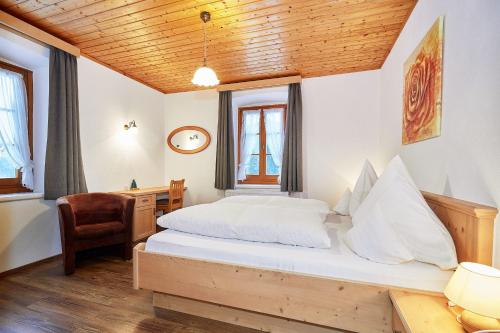 雷特温克尔Haus Benzmühle的一间卧室配有一张床、一张桌子和一把椅子