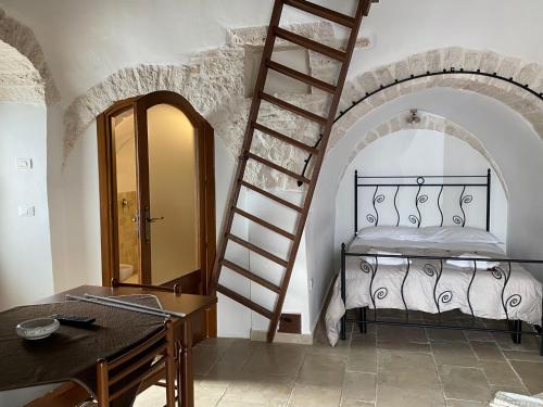 阿尔贝罗贝洛Trulli Antichi Mestieri - Widespread Trulli in the historic center的卧室配有一张床,房间内设有梯子