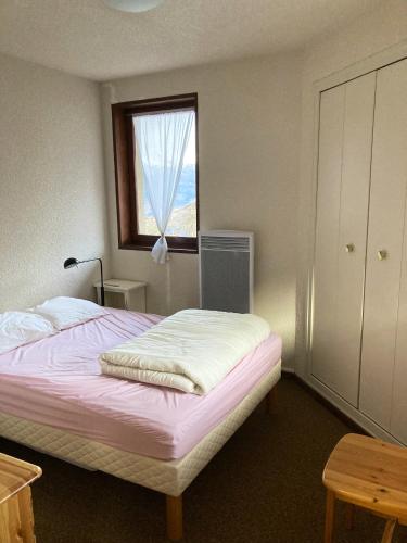 莱索尔Appartement de 2 chambres avec balcon amenage a Les Orres a 2 km des pistes的一间卧室配有一张带窗户和梳妆台的床
