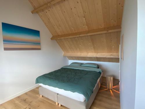 PolsbroekDe Porrel Polsbroek Unit met Privé Jacuzzi, Spa en Sauna的木天花板的客房内的一张床位