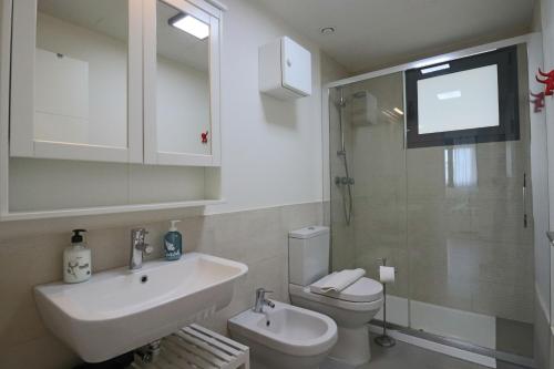 厄尔-汝姆披多Enjoy La Reserva El Rompido的一间带水槽和卫生间的浴室以及一台电视。
