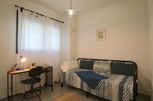 厄尔-汝姆披多Enjoy La Reserva El Rompido的一间卧室配有一张床、一张书桌和一个窗户。