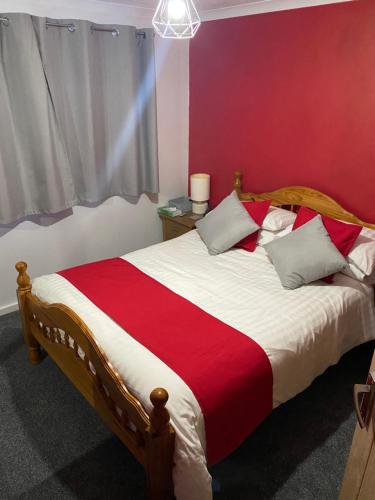 普里茅斯Southway Double Room near Derriford的一间卧室配有一张带红白毯子的床