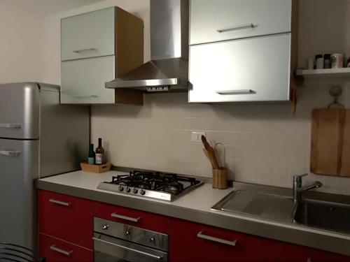 法诺Raki Apartment的厨房配有白色橱柜、炉灶和水槽。