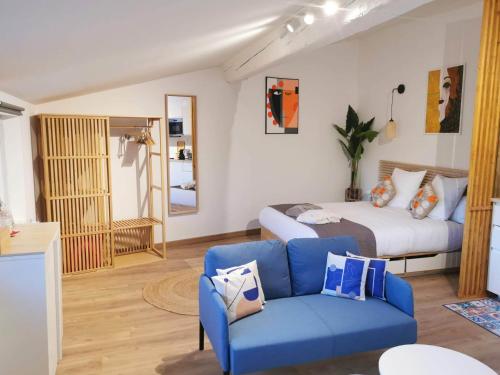 阿尔勒Arles Holiday - Le Refuge的一间卧室配有一张床和一张蓝色的沙发