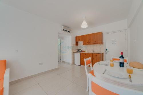 阿依纳帕Christos Napa Apartments的白色的厨房配有桌椅和台面