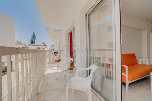 阿依纳帕Christos Napa Apartments的阳台配有橙色椅子和沙发。