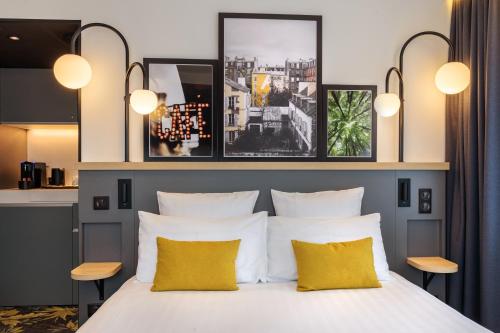 阿涅勒Best Western M-Treize Paris Asnieres的一间卧室配有一张带两个黄色枕头的床