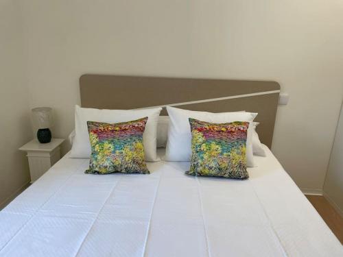 埃斯波森迪Casa Fermar的一张带两个枕头的白色床