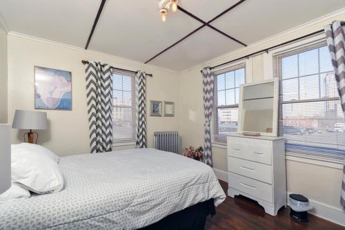 哈特福德The Wadsworth Suite A2的一间卧室设有一张床、一台电视和窗户。