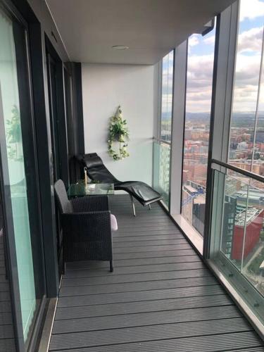 曼彻斯特Luxury apartment stunning views的大楼内带桌椅的阳台