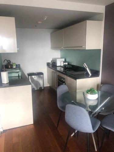 曼彻斯特Luxury apartment stunning views的厨房配有桌椅和柜台。