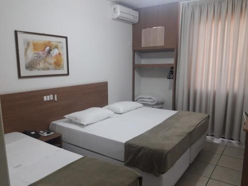埃雷欣Hotel Vivendas Centro的酒店客房设有两张床和窗户。