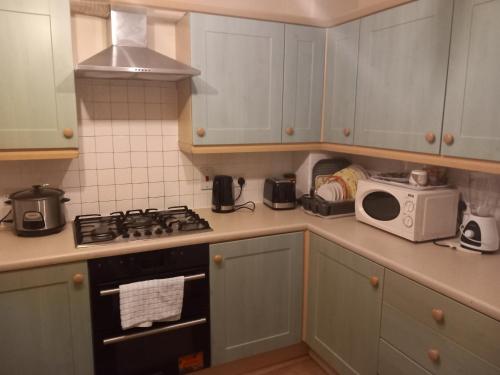 ThamesmeadLovely Shared 3 Bed Home Near The Thames的厨房配有炉灶和微波炉。