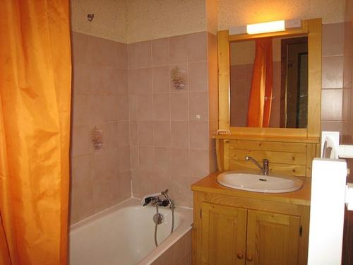 拉克吕萨Appartement La Clusaz, 3 pièces, 8 personnes - FR-1-459-5的带浴缸、水槽和镜子的浴室