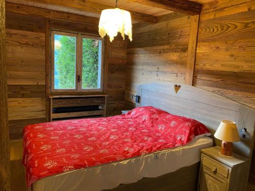 拉克吕萨Appartement La Clusaz, 3 pièces, 6 personnes - FR-1-459-28的小木屋内一间卧室配有红色的床