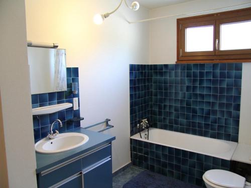 拉克吕萨Appartement La Clusaz, 4 pièces, 6 personnes - FR-1-459-99的蓝色瓷砖浴室设有水槽和卫生间
