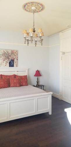 查塔努加The Mayor's Mansion Inn的客房内的白色床和红色枕头