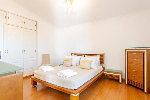 塔维拉Suite Bela Vista的一间卧室配有一张带白色床单的床和梳妆台。