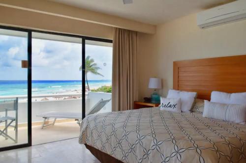 坎昆Ocean front Villa in Cancun Hotel Zone的一间卧室配有一张床,享有海滩美景