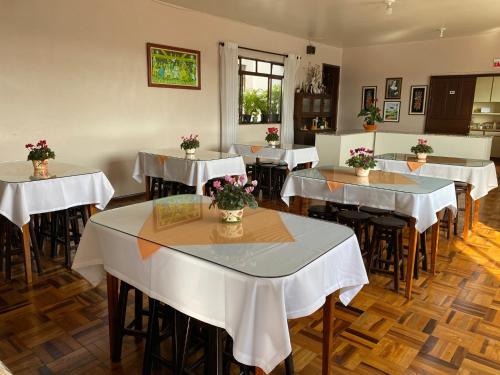拉热斯Pousada Irmãs Franciscanas的餐厅设有桌椅,并种有鲜花