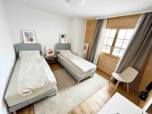 威拉尔-苏-罗伦Apartment with stunning view! Ski-in, ski-out的一间卧室设有两张床、一把椅子和一个窗户。