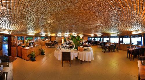 帕皮提皇家塔赫缇恩酒店的一间带桌椅和大型天花板的餐厅