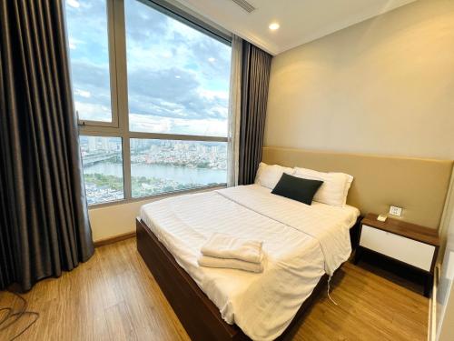 胡志明市The Landmark Vinhomes-Service Apartment的一间卧室设有一张大床和大窗户
